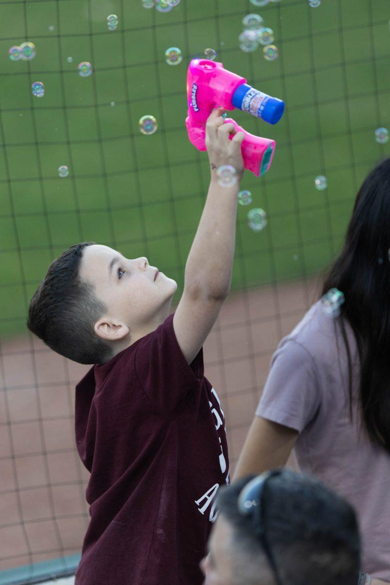 A young fan plays with a bubble gun during Texas A&Ms game against St. Thomas on Feb. 23, 2024 at Davis Diamond. (Jaime Rowe/The Battalion)