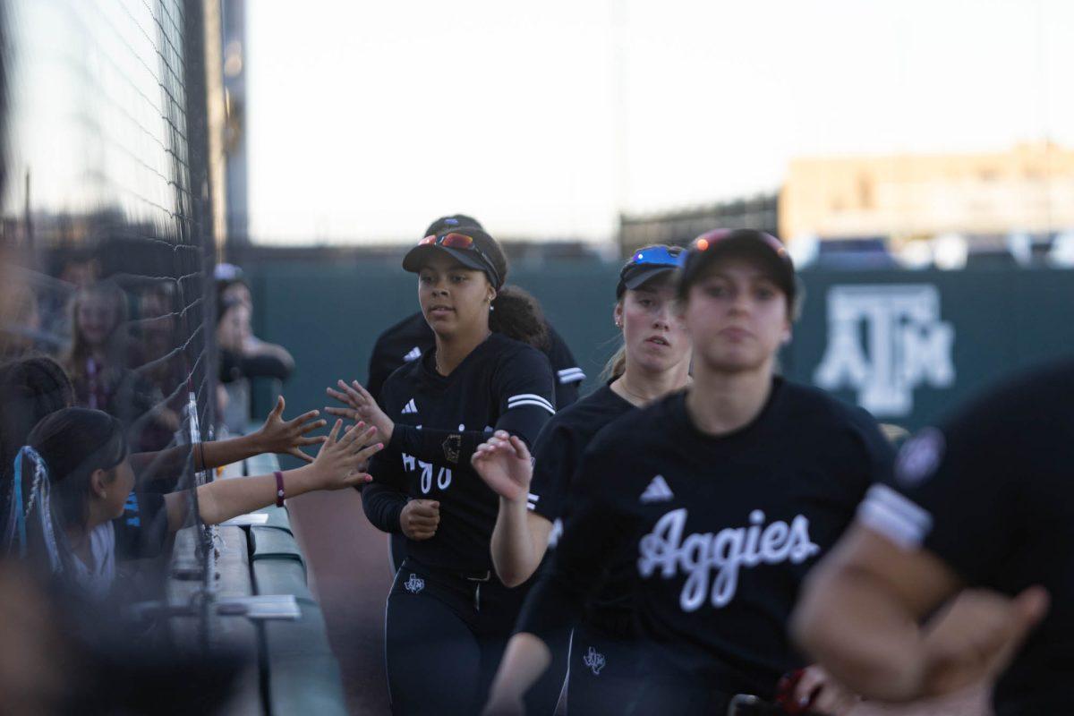 The Texas A&M softball team high fives fans during Texas A&Ms game against Kansas State on Feb. 24, 2024 at Davis Diamond. (Jaime Rowe/The Battalion)