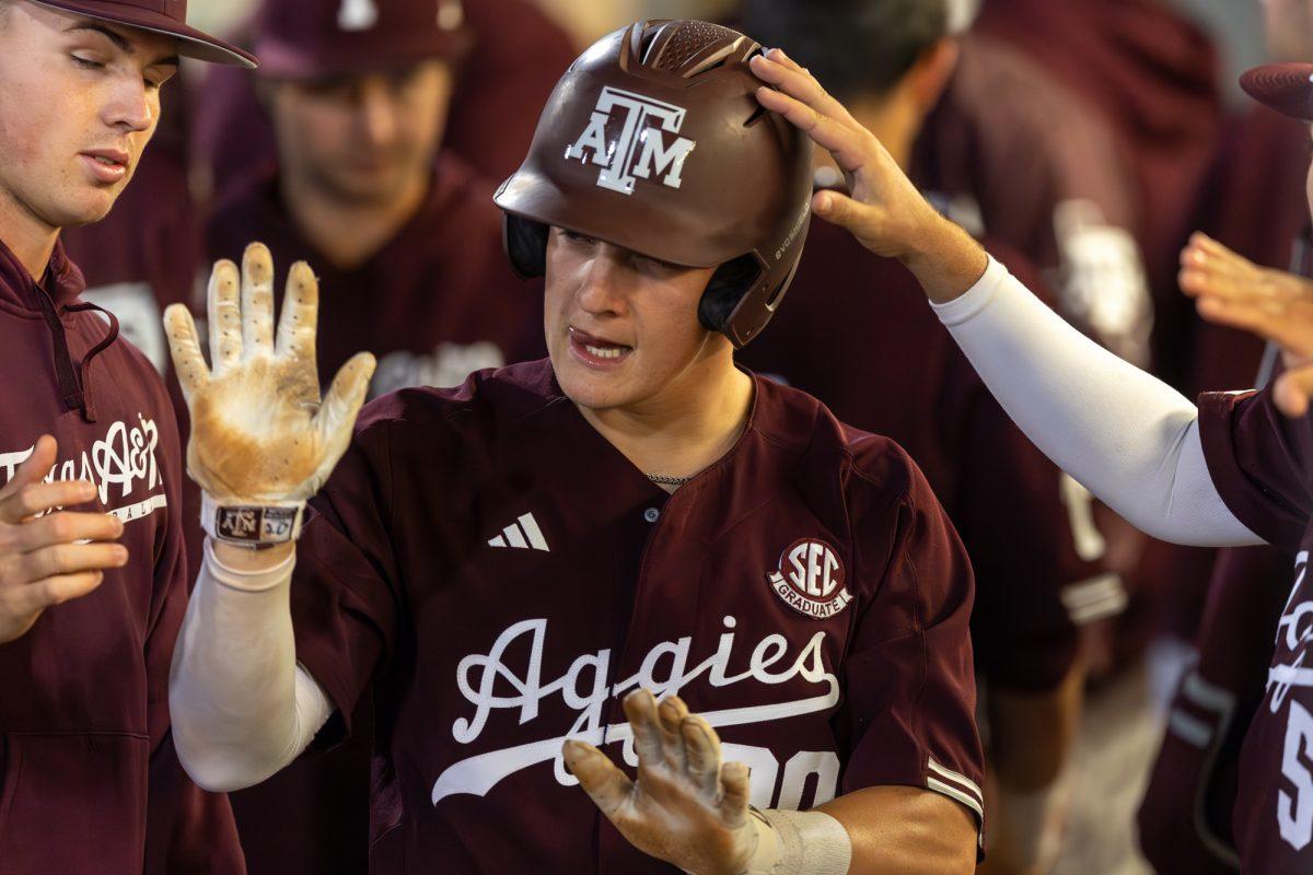 Senior C Jackson Appel (20) high-fives his teammates during A&Ms games against Houston Christian University on Tuesday, March 26, 2024, at Olsen Field. (CJ Smith/The Battalion)