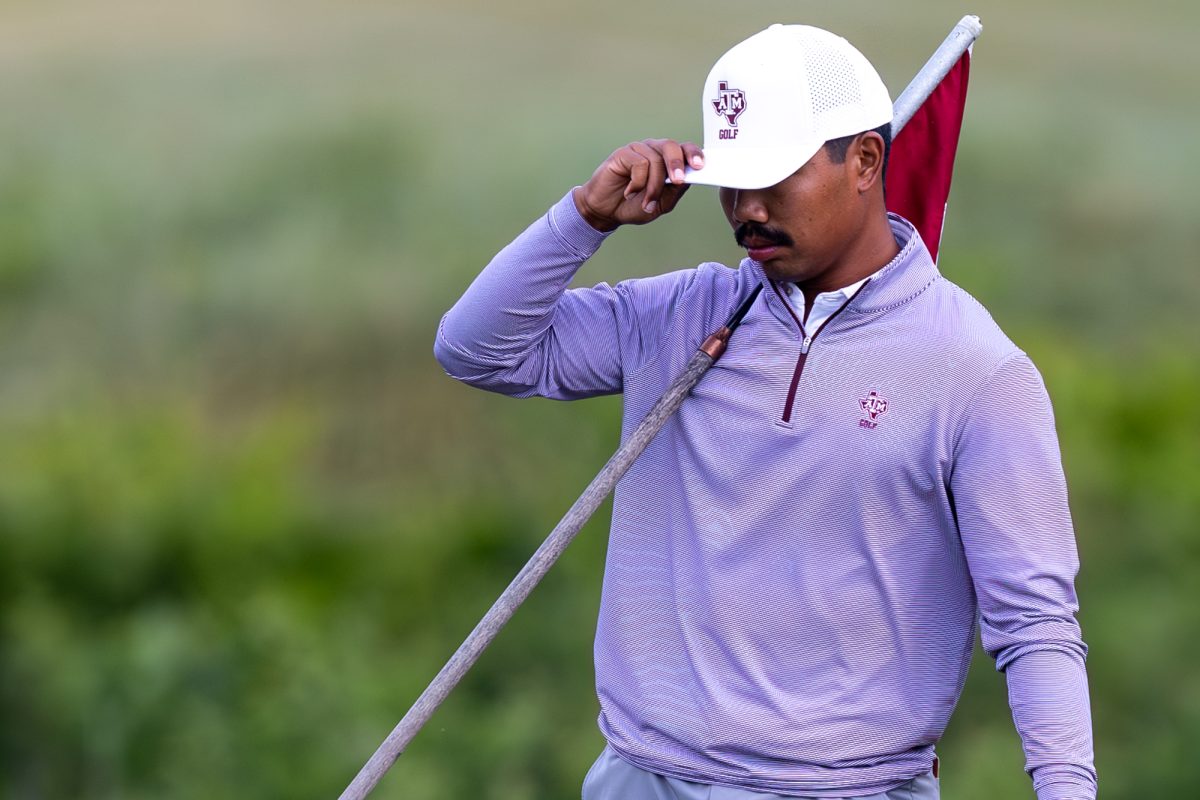 Texas A&amp;M junior Phichaksn Maichon stands with a flag during The Aggie Invitational on Saturday, April 6, 2024, at Traditions Golf Club. (CJ Smith/The Battalion)