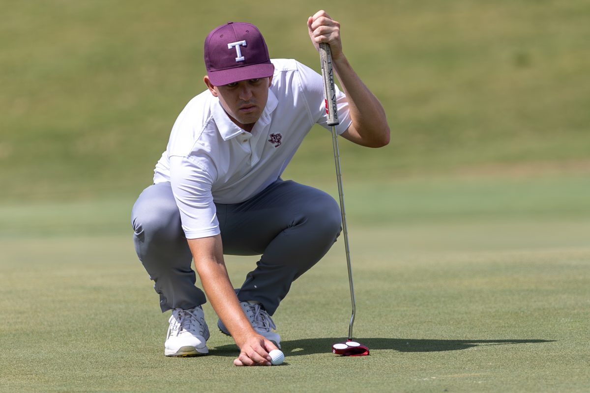 Texas A&M senior Daniel Rodrigues lines up the ball during The Aggie Invitational on Saturday, April 6, 2024, at Traditions Golf Club. (CJ Smith/The Battalion)