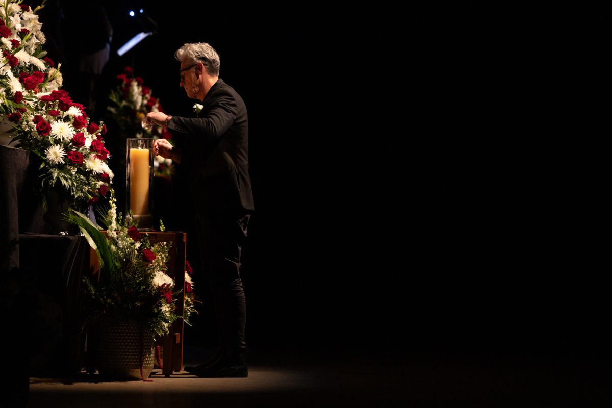 A candleholder lights the first candle during the 100th annual Muster ceremony held at Reed Arena on Sunday, April 21, 2024.