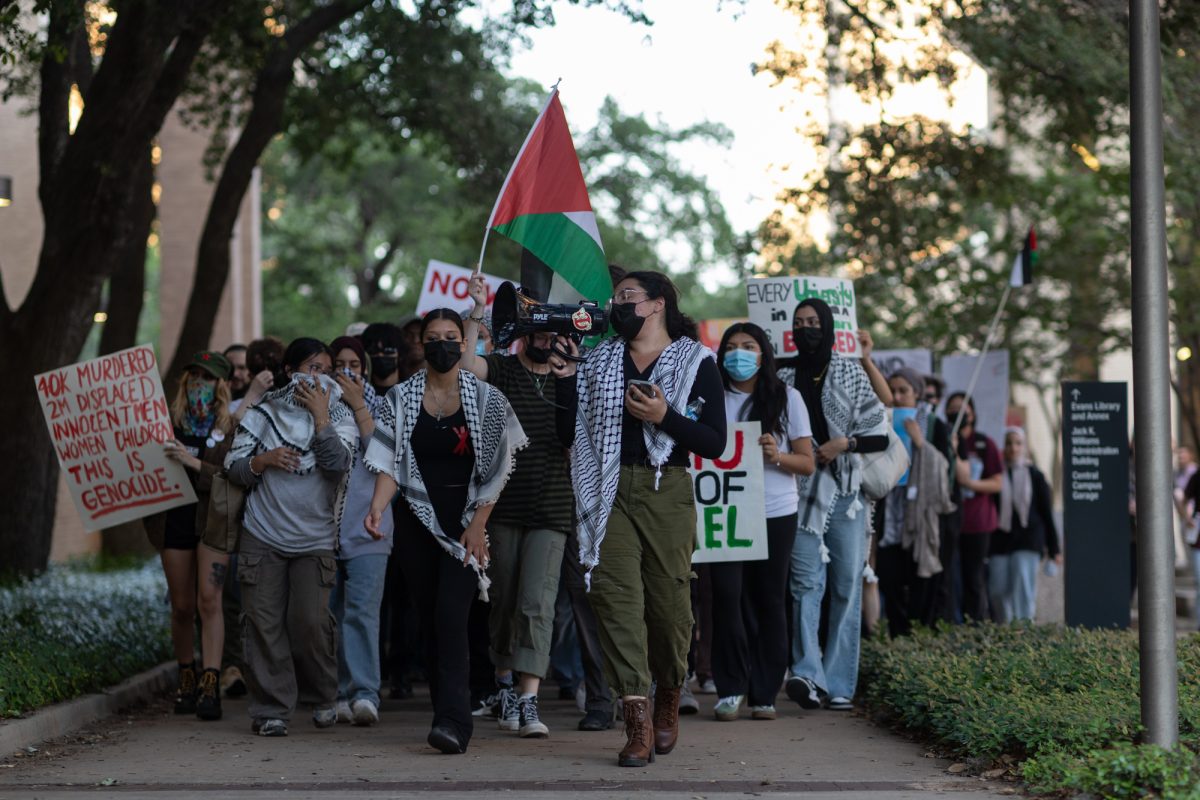 Demonstrators march past Evans Library during a protest against the university funding of organizations that support the conflict in Gaza on Monday, April 29, 2024. 