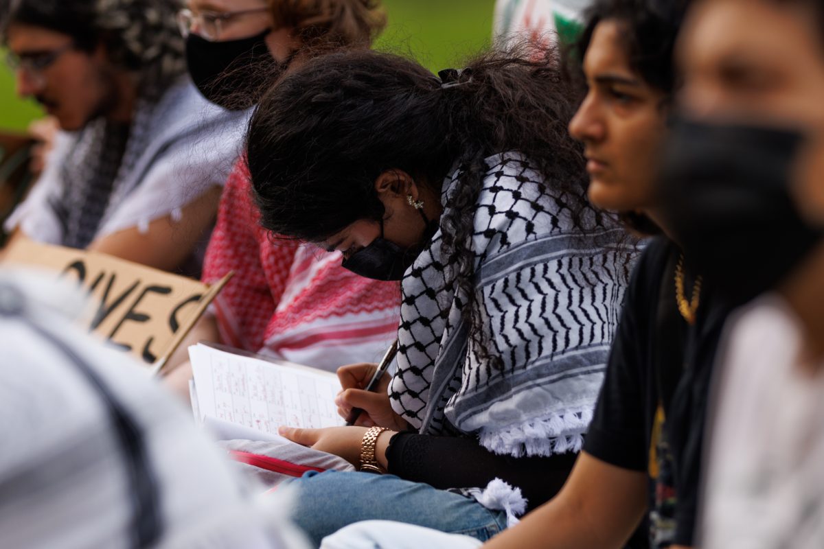 Demostrators sign a petition for TAMU to stop relations with organizations with links to Isreal during a free Palestine protest on May 7, 2024. (Samuel Falade/The Battalion)