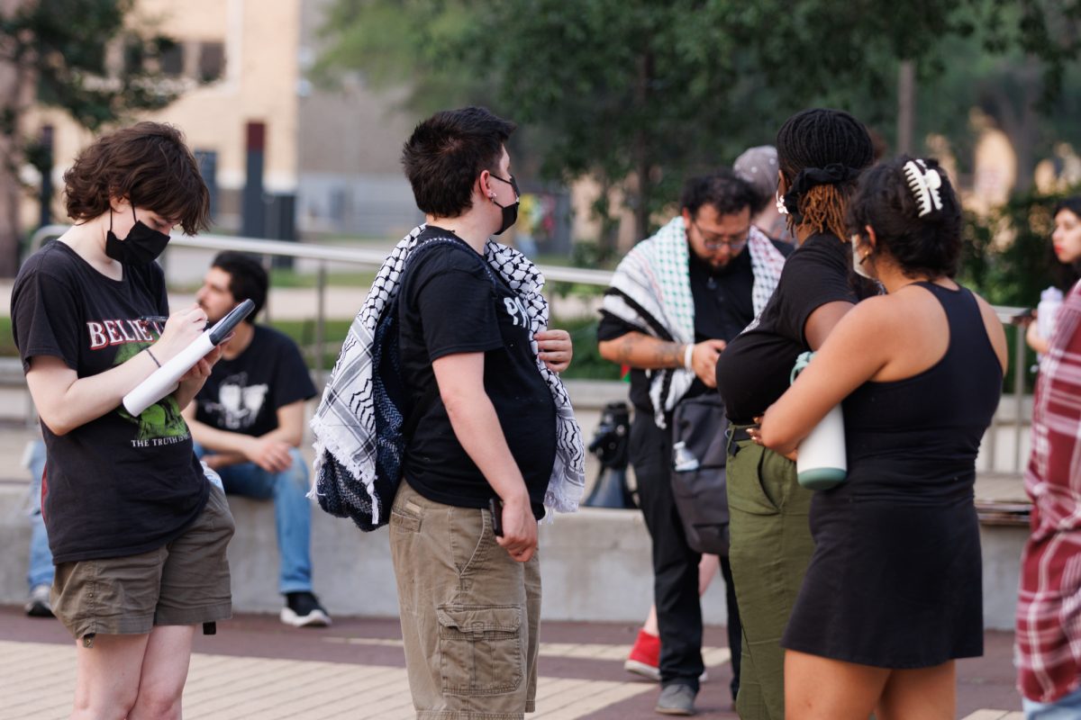 Demostrators sign a petition for TAMU to stop relations with organizations with links to Isreal during a free Palestine protest on May 7, 2024. (Samuel Falade/The Battalion)