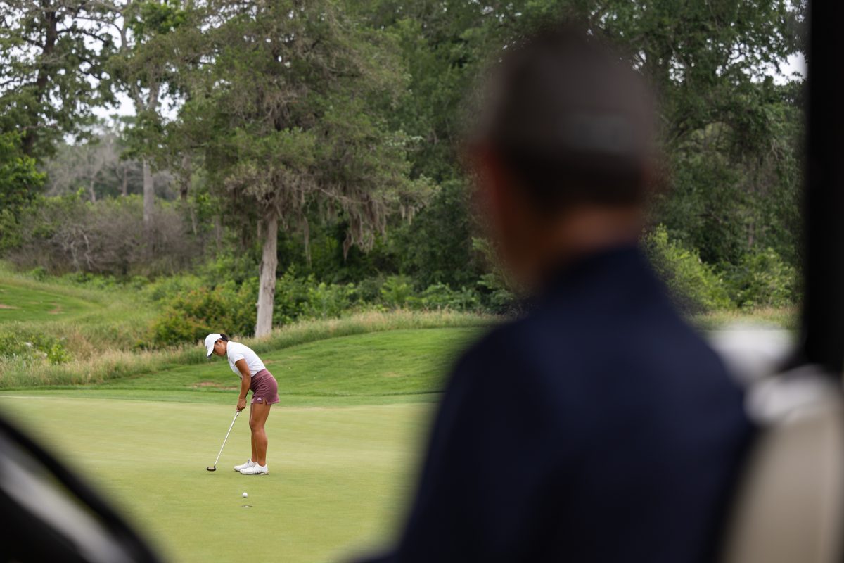 A scorekeeper watches Texas A&M senior Zoie Slaughter putt during the Bryan Regional of the NCAA Women’s Golf Championship at Traditions Golf Club on Monday, May 6, 2024. (Chris Swann/ The Battalion)