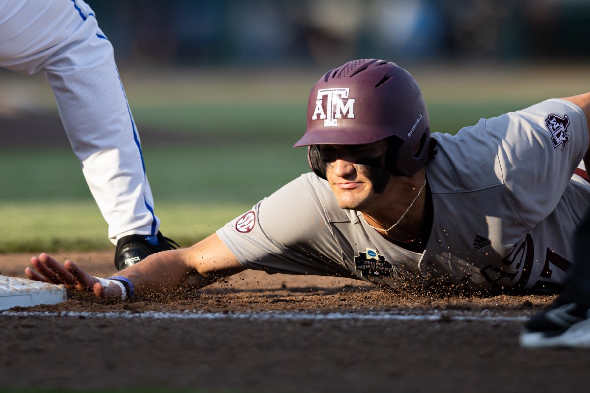 Texas A&M outfielder Jace Laviolette (17) dives to first during Texas A&M’s game against Kentucky at the NCAA Men’s College World Series at in Omaha, Nebraska on Monday, June 17, 2024. (Chris Swann/The Battalion)