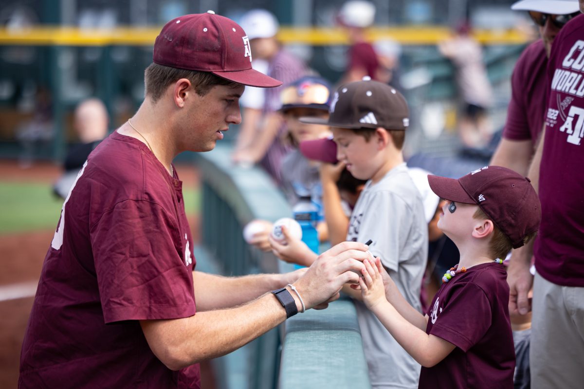 Texas A&M pitcher Justin Lamkin (33) signs memorabillia from fans before Texas A&M’s game against Kentucky at the NCAA Men’s College World Series at in Omaha, Nebraska on Monday, June 17, 2024. (Chris Swann/The Battalion)