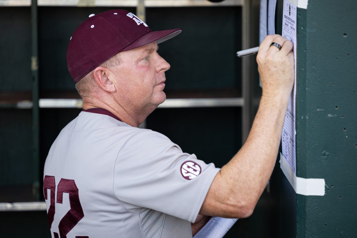 Texas A&M head coach Jim Schlossnagle (22) signs the lineup sheet before Texas A&M’s game against Tennessee at the NCAA Men’s College World Series finals at Charles Schwab Field in Omaha, Nebraska on Monday, June 24, 2024. (Chris Swann/The Battalion)