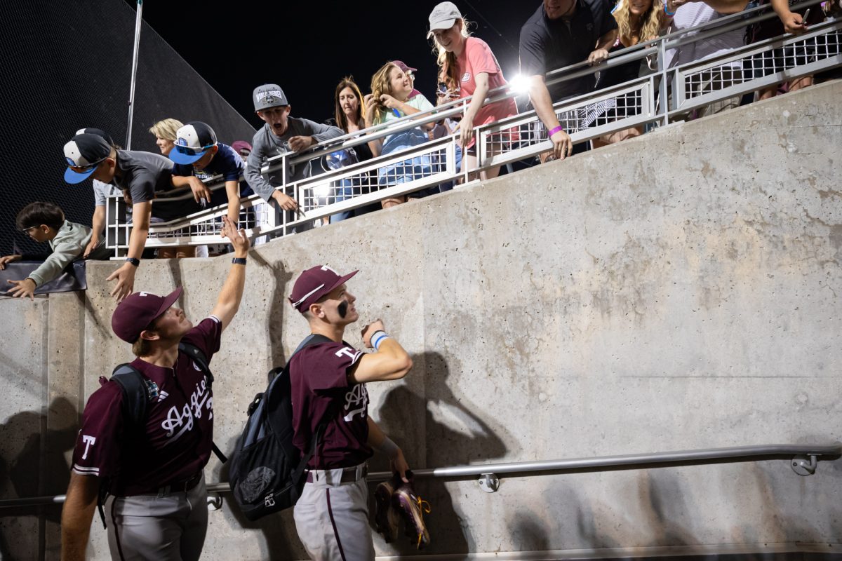 Texas A&M pitcher Josh Stewart (34) and outfielder Caden Sorrell (13) greet fans as they leave the field after Texas A&M’s win against Florida at the NCAA Men’s College World Series semifinals at Charles Schwab Field in Omaha, Nebraska on Wednesday, June 19, 2024. (Chris Swann/The Battalion)