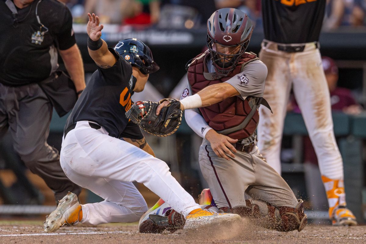 Tennessee outfielder Hunter Ensley (9) dodges a tag from Texas A&M catcher Jackson Appel (20) during Texas A&M’s game against Tennessee at the NCAA Men’s College World Series finals at Charles Schwab Field in Omaha, Nebraska on Monday, June 24, 2024. (Hannah Harrison/The Battalion)