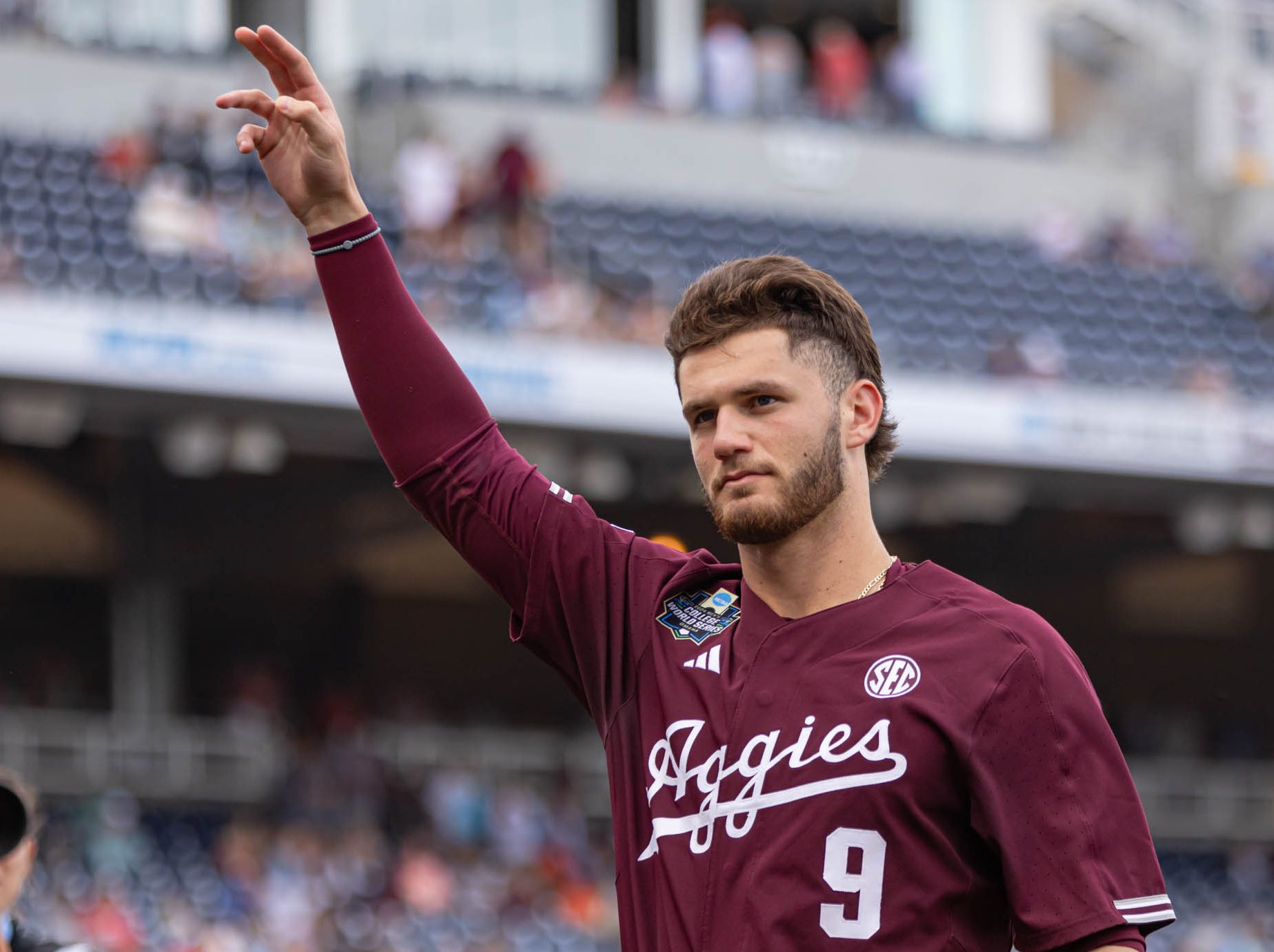 Texas A&amp;M utility Gavin Grahovac (9) waves while entering the dugout during Texas A&amp;M’s game against Florida at the NCAA Men’s College World Series semifinal at Charles Schwab Field in Omaha, Nebraska on Sunday, June 19, 2024. (Hannah Harrison/The Battalion)