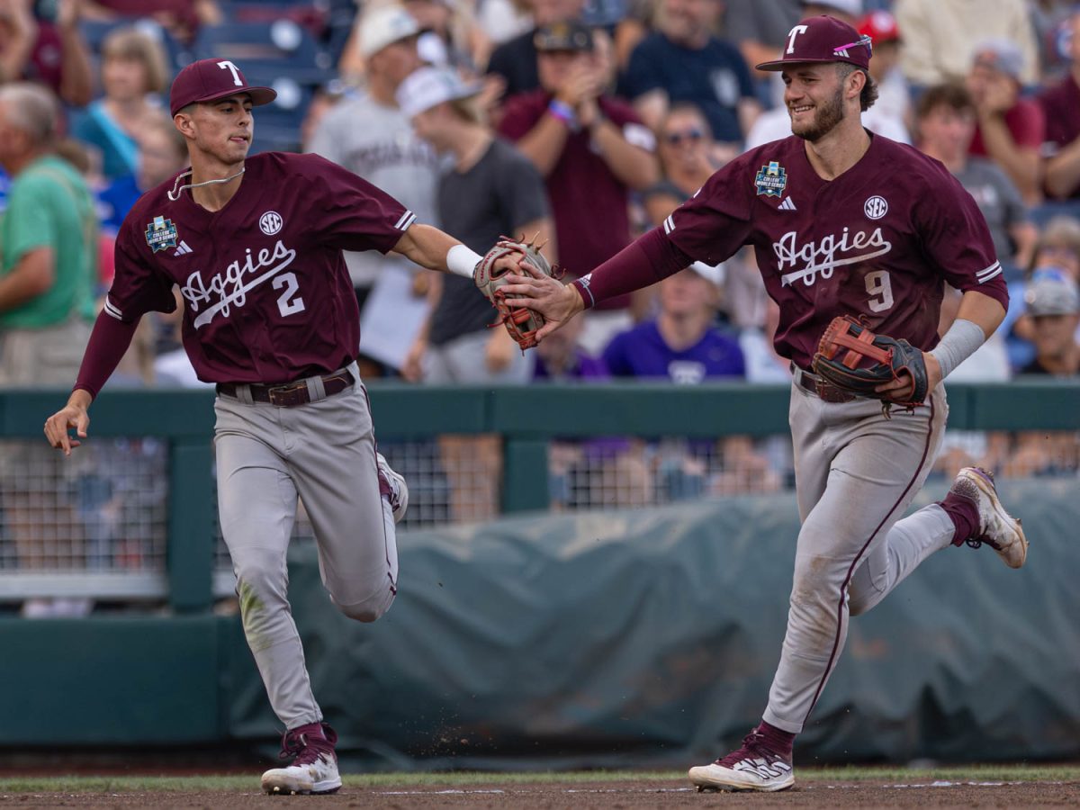 Texas A&M infielder Ali Camarillo (2) high-fives Texas A&M utility Gavin Grahovac (9) after an out during Texas A&M’s game against Florida at the NCAA Men’s College World Series semifinal at Charles Schwab Field in Omaha, Nebraska on Sunday, June 19, 2024. (Hannah Harrison/The Battalion)