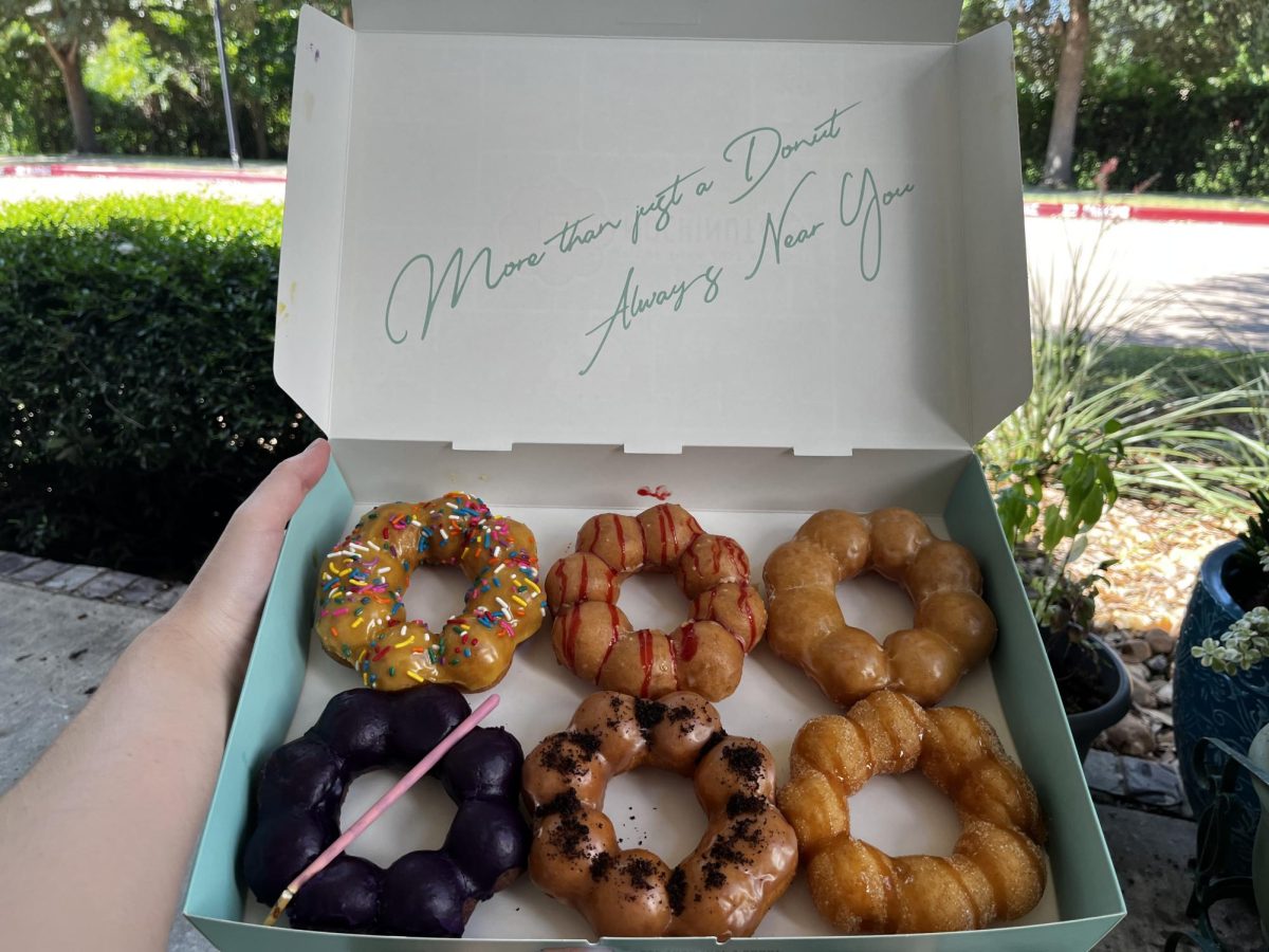 Writer Braxton Dore with the six Mochinut donuts he sampled from the restaurant. The writing on the box lid reads, More than just a donut, always near you.