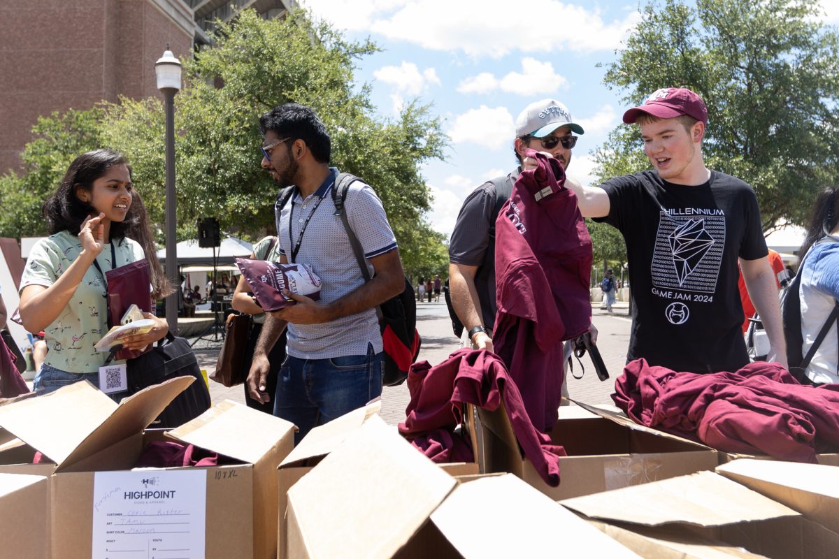 Students pick up a class of 2028 T-shirt from boxes during the Howdy Week Ice Cream Carnival at the Kyle Field Plaza on Friday, Aug. 16, 2024. 