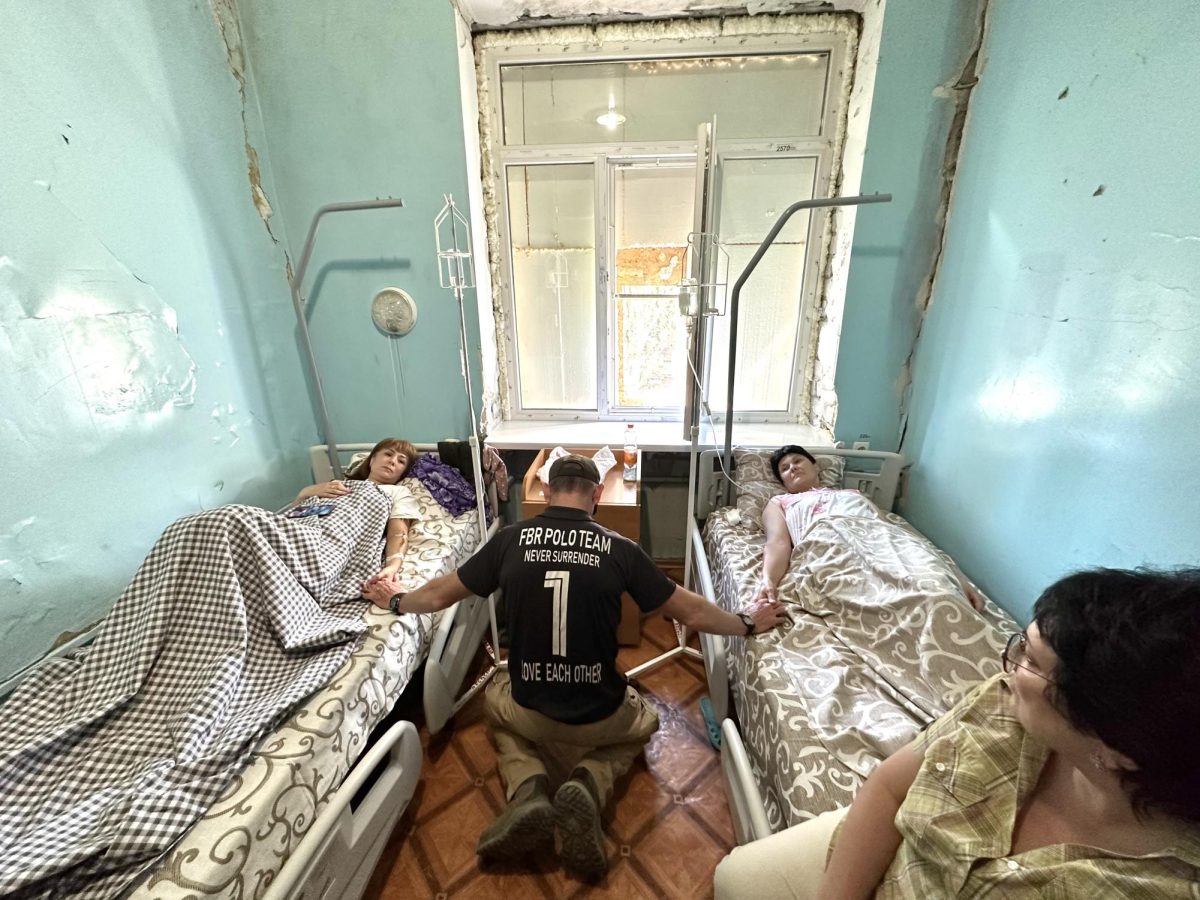 David Eubank prays over wounded civilians during a Free Burma Rangers mission in Ukraine. (Photo courtesy of David Eubank)