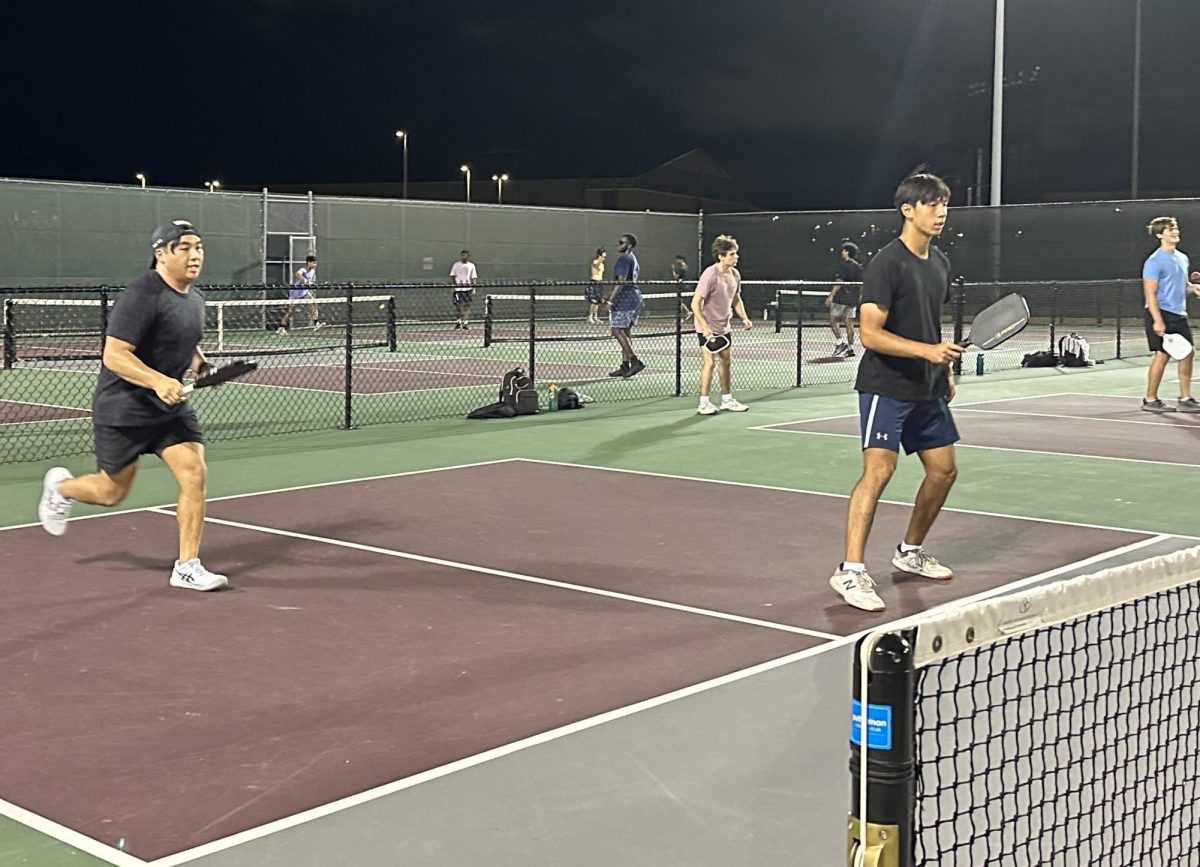 Industrial engineering junior Kyle Nguyenphu runs forward after his serve while civil engineering sophomore Elvin Jaya waits for their opponent, Hajjplayspickle, to return it during their final regular season match of the Doubles Competitive Pickleball League on Sept. 11, 2024 at Omar Smith Instructional Tennis Center.