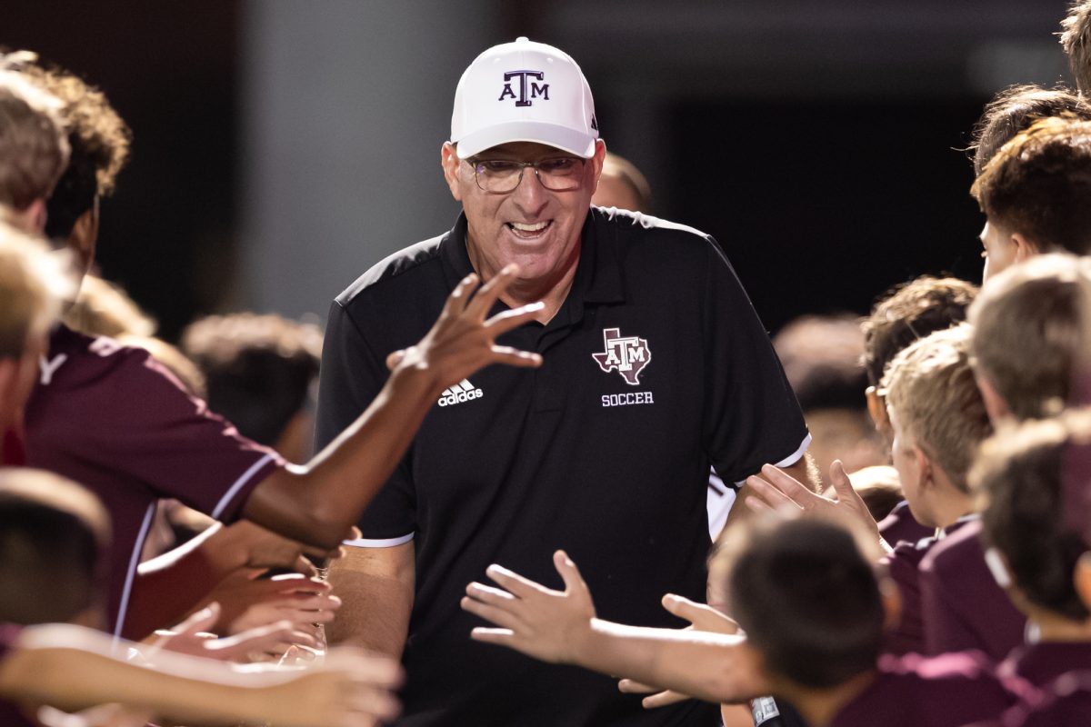 Texas A&amp;M head coach G Guerrieri high fives fans as he runs back to the field after half time during Texas A&amp;M’s game against TCU at Ellis Field on Thursday, Sept. 5, 2024. (Chris Swann/The Battalion)