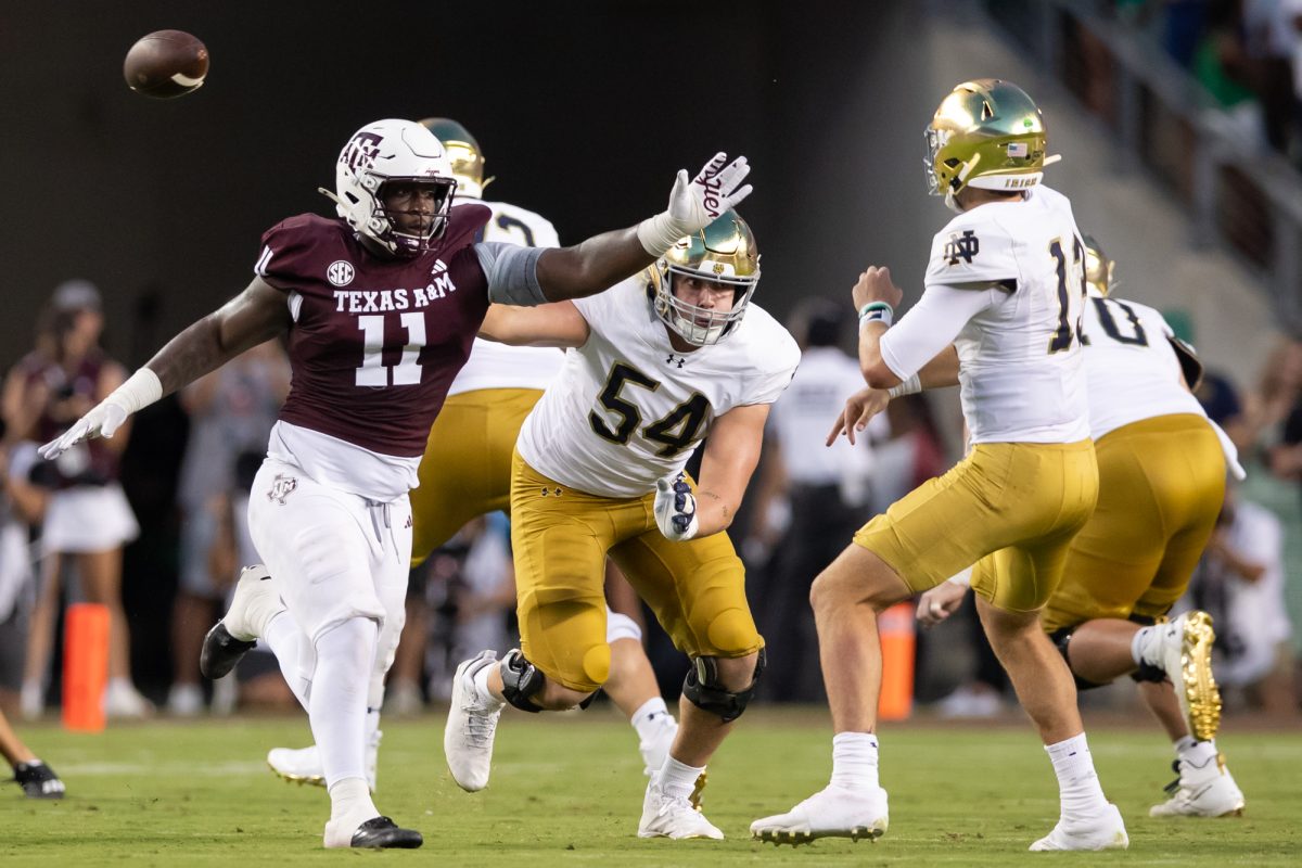 Texas A&M defensive lineman Nic Scourton (11) attempts to tip the ball from Notre Dame quarterback Riley Leonard (13)  during Texas A&M’s game against Notre Dame at Kyle Field on Saturday, Aug. 31, 2024. (Chris Swann/The Battalion)