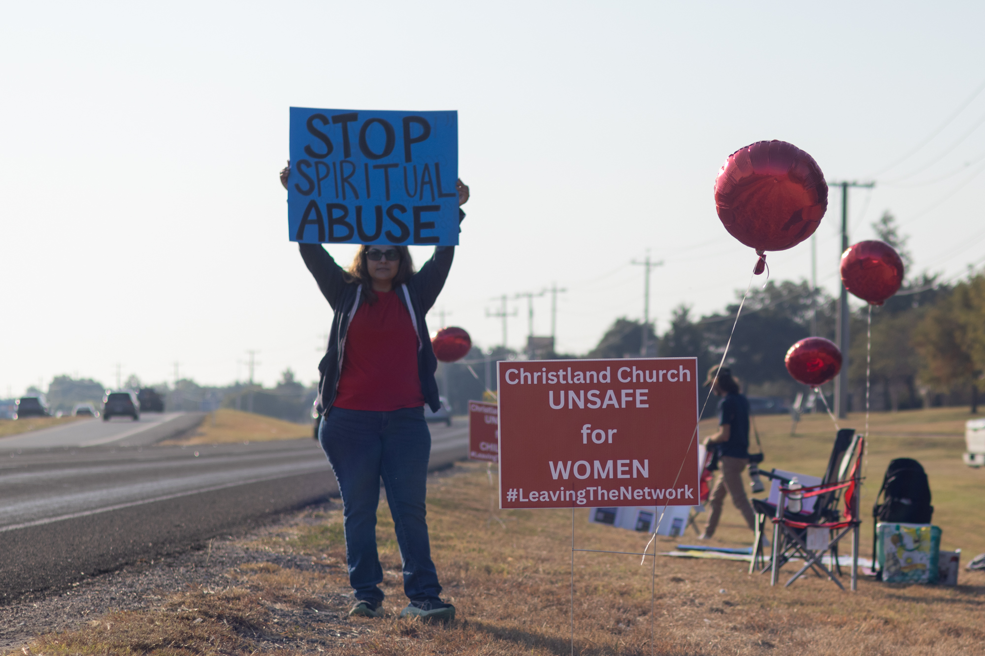 Protesters Vera Hernandez and Catherine Hunter demonstrate on the roadside protesting against alleged abuses by the Christland Church on Saturday, Oct. 12, 2024.