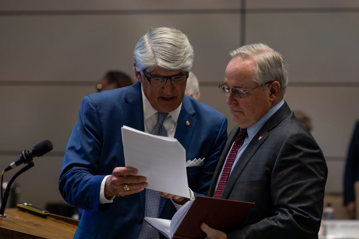 Michael J. Plank discusses the agenda with President Mark A. Welsh III before the Board of Regents meeting on Thursday, November 7, 2024. (Jackson Stanley/The Battalion)