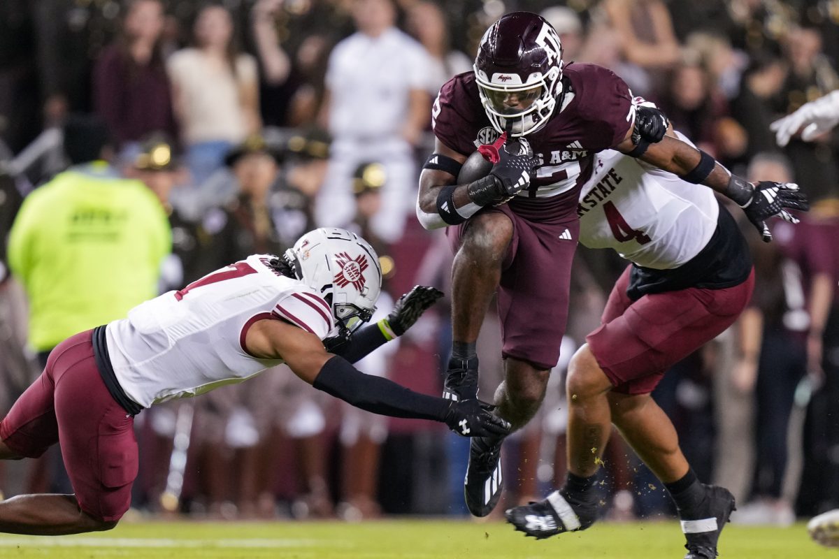 Texas A&amp;M running back EJ Smith (22) jumps over a New Mexico State defender during Texas A&amp;M’s game against New Mexico State at Kyle Field on Saturday, Nov. 16, 2024. (Hannah Harrison/The Battalion)