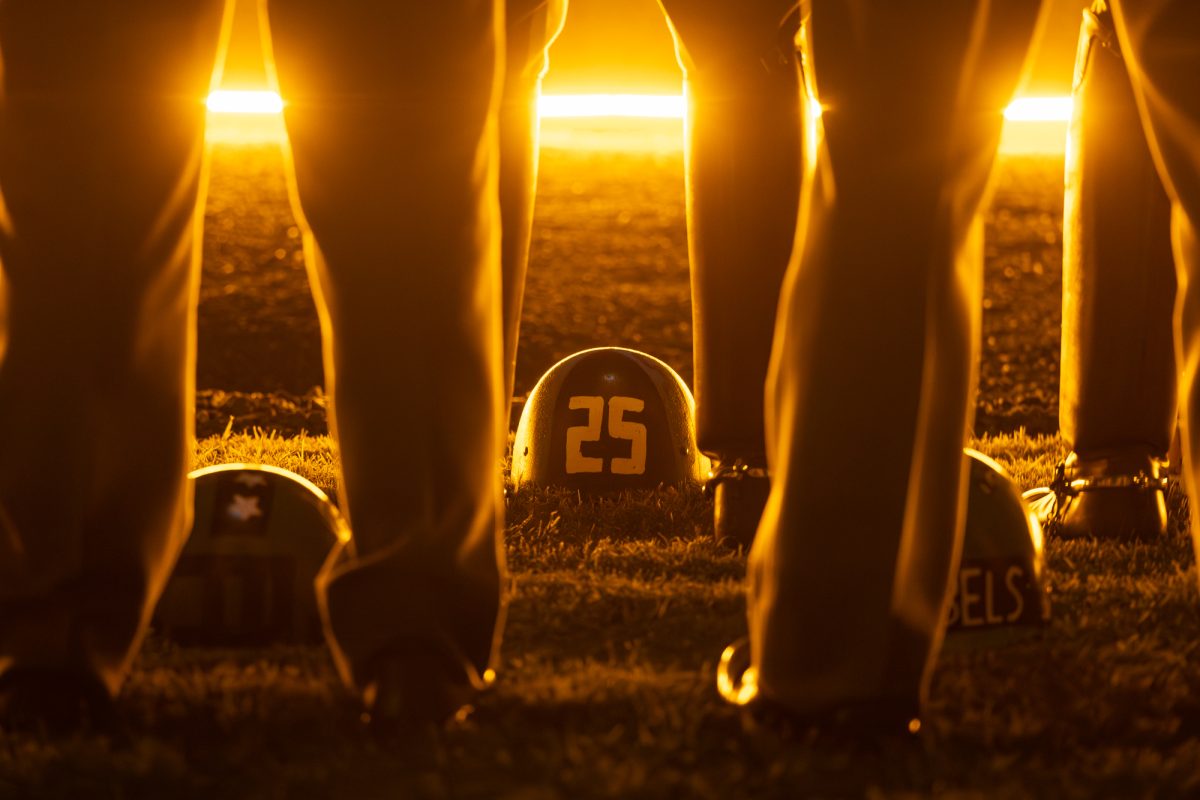 Members of E-2 Company set helmets down in front of them before the Bonfire Remembrance Ceremony at the Bonfire Memorial on Monday, Nov. 18, 2024. 