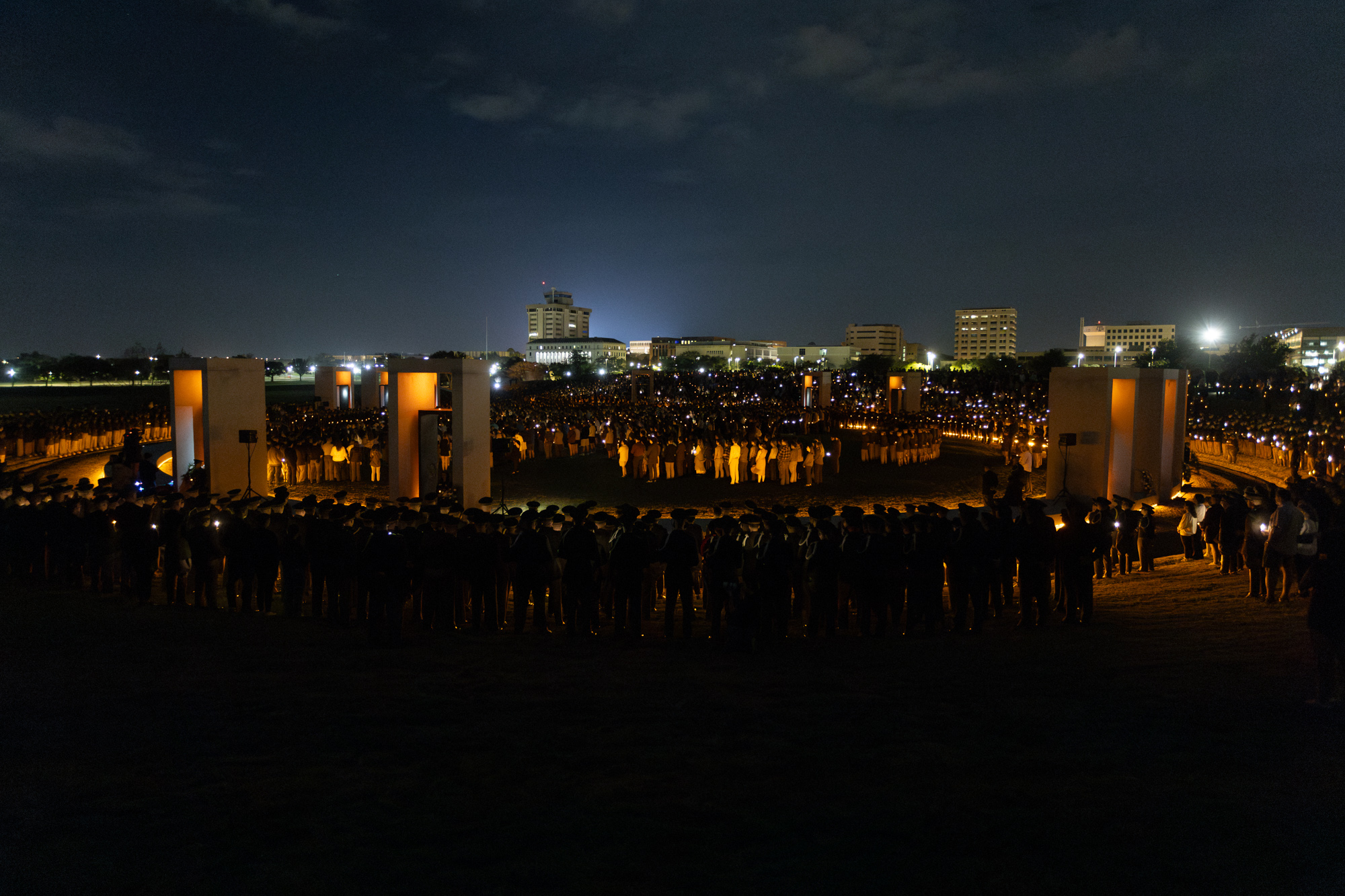 The Bonfire memorial stands illumated as attendees hold candles in honor of the 12 fallen Aggies during the Remembrance Ceremony on Monday, Nov. 18, 2024.