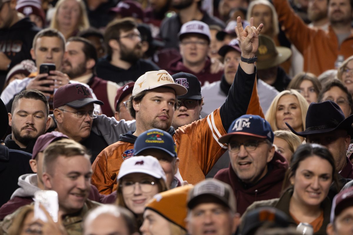 A texas fan flashes a ‘Horns Up’ while fans sing the Aggie War Hymn during Texas A&amp;M’s game against Texas at Kyle Field on Saturday, Nov. 30, 2024. (Chris Swann/The Battalion)