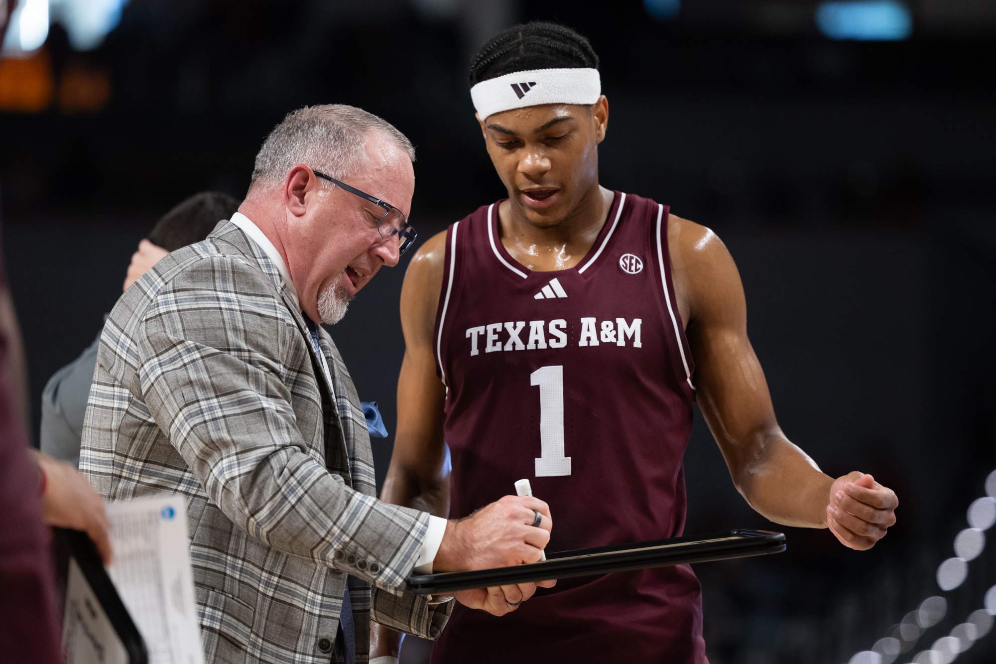 Texas A&amp;M head coach Buzz Williams draws a play in front of guard Zhuric Phelps (1) during Texas A&amp;M’s game against Texas Tech at Dickies Arena in Fort Worth, Texas on Sunday, Dec. 8, 2024. (Chris Swann/The Battalion)