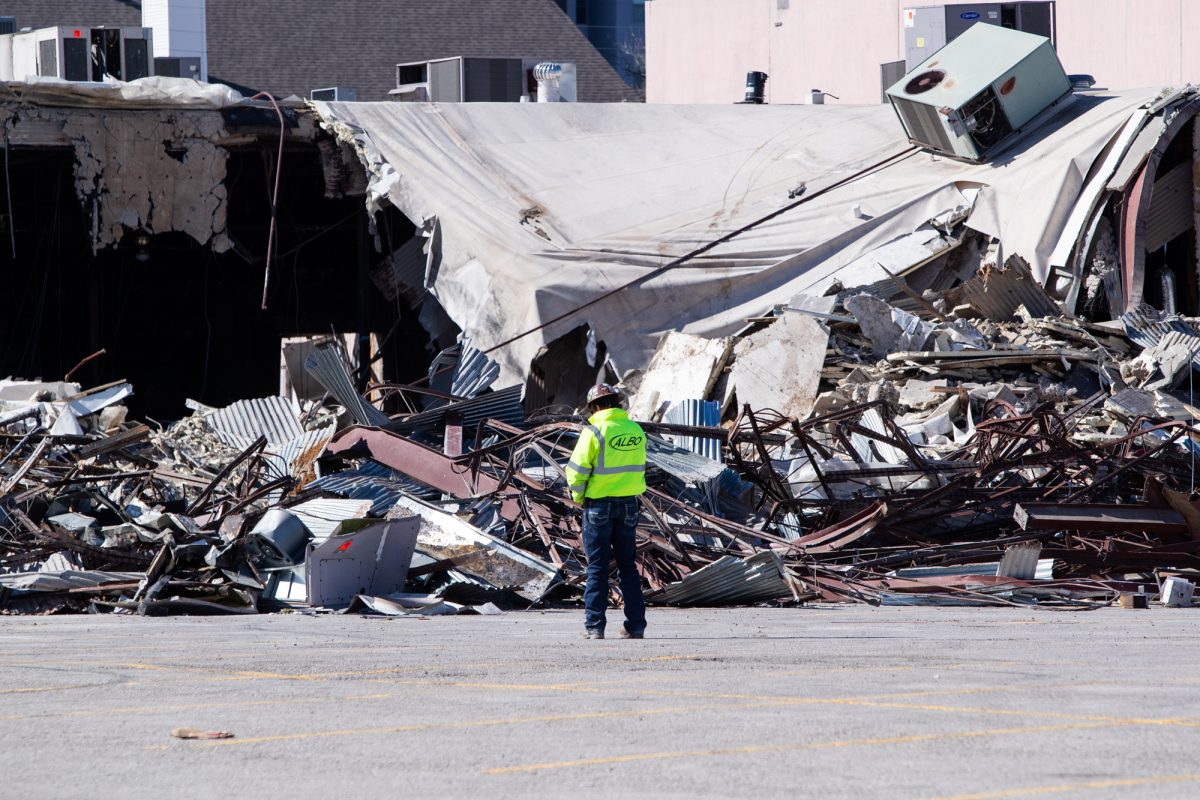 A demolition worker stands before a partially demolished Hurricane Harry's. 