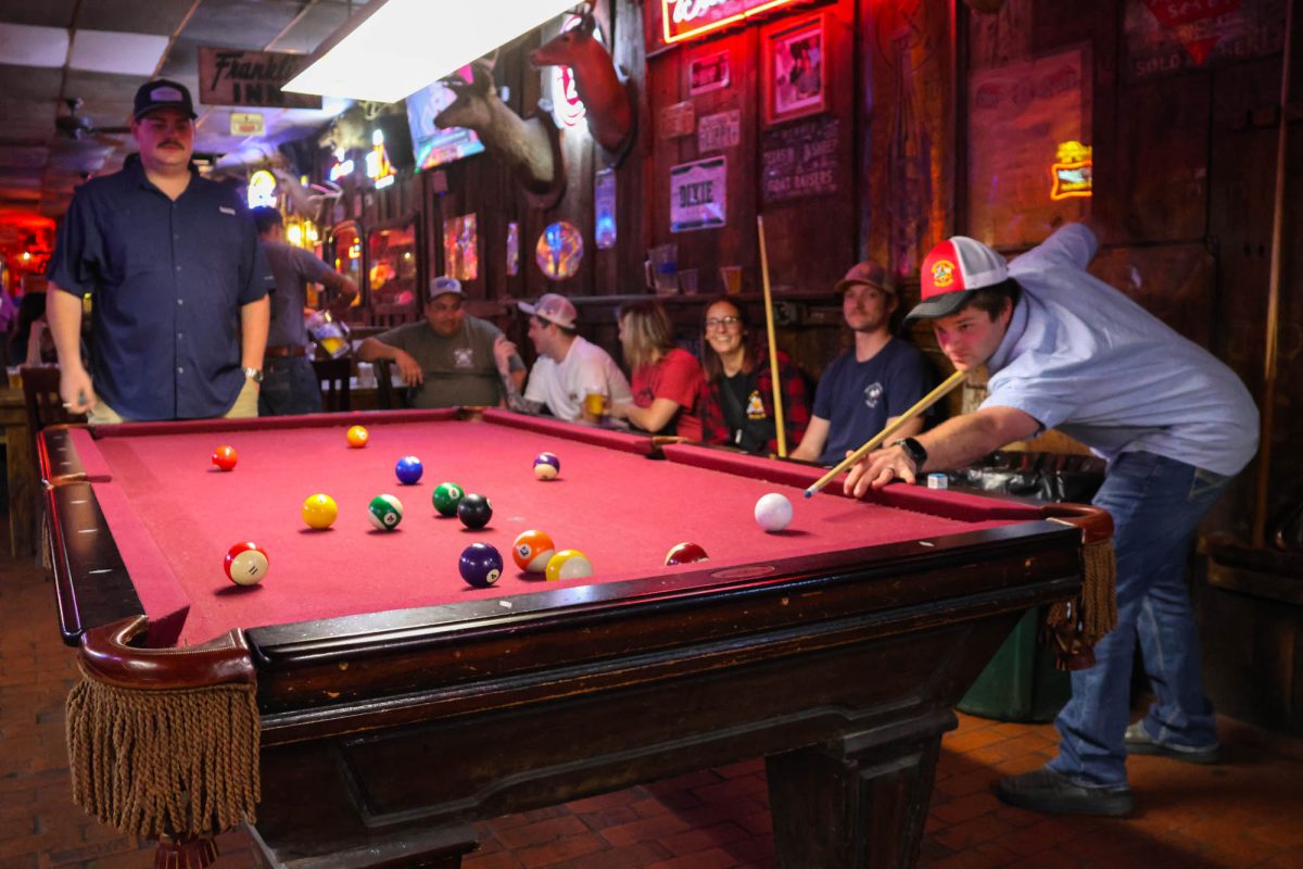 Frequent patrons play a game of pool at the Dixie Chicken on Tuesday, Feb. 4, 2025. (Kennedy Long/The Battalion)